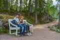 Handsome middle-aged man and young pretty lady sitting on bench Royalty Free Stock Photo
