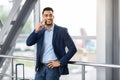 Handsome Middle Eastern Businessman Talking On Cellphone While Waiting At Airport Terminal Royalty Free Stock Photo