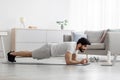 Handsome millennial bearded arabian guy doing plank exercises in bedroom