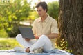 Handsome millennial guy working on laptop at park Royalty Free Stock Photo