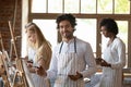 Painter man holding palette and paintbrush posing in art studio Royalty Free Stock Photo