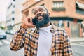 Handsome modern african american man with beard speaking on the phone at the city with a happy smile Royalty Free Stock Photo