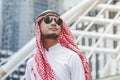 Handsome modern Arabian man standing in modern city wear muslim dress headscarf eastern ethnic smile outside office. Arab Man