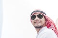 Handsome modern Arabian man standing in modern city wear muslim dress headscarf eastern ethnic smile outside office. Arab Man