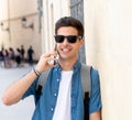 Handsome modern happy young man talking on his smart phone outsi Royalty Free Stock Photo