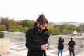 Arabian boy walking near Eiffel Tower with smartphone in slow mo Royalty Free Stock Photo