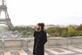 Arabian boy walking near Eiffel Tower with smartphone in slow mo Royalty Free Stock Photo