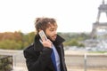 Arabian boy walking near Eiffel Tower with smartphone in slow mo Royalty Free Stock Photo