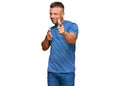 Handsome muscle man wearing casual clothes pointing fingers to camera with happy and funny face