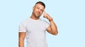 Handsome muscle man wearing casual white tshirt smiling pointing to head with one finger, great idea or thought, good memory