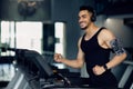 Handsome Muscular Arab Man In Wireless Headphones Jogging On Treadmill At Gym Royalty Free Stock Photo