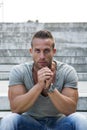 Handsome muscular blond man sitting on stair steps Royalty Free Stock Photo