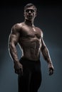 Handsome muscular bodybuilder posing over black background