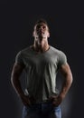 Handsome muscular fit young man on dark background looking up Royalty Free Stock Photo