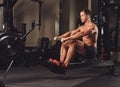 Handsome muscular fitness male doing exercise on the rowing machine.