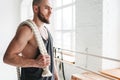 Handsome muscular man holding on shoulder rope workout in light gym