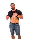 Handsome,muscular man pulling up t-shirt revealing abs. Isolated