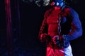 Handsome muscular man with training mask working out with weightlifting chains in the park at nighttime, street workout in the Royalty Free Stock Photo