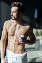 Handsome, muscular, young man drinking his morning coffee in a h Royalty Free Stock Photo