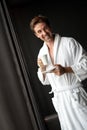 Handsome, muscular, young man drinking his morning coffee in a hotel room Royalty Free Stock Photo