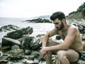 Young man sitting on a beach alone