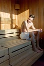 Handsome, muscular, young man sitting in a sauna alone thinking Royalty Free Stock Photo