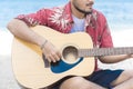 Handsome Musician Man Playing acoustic guitar at the beach. Chill out lifestyle Travel Concept Royalty Free Stock Photo