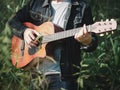 Handsome musician playing acoustic guitar at the grass field blur background. World music day. music and instrument concept Royalty Free Stock Photo