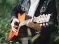 Handsome musician playing acoustic guitar at the grass field blur background. World music day. music and instrument concept Royalty Free Stock Photo