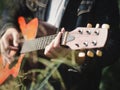 Handsome musician playing acoustic guitar at the grass field blur background. World music day. music and instrument concept Royalty Free Stock Photo