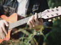 Handsome musician playing acoustic guitar at the grass field blur background. World music day. music and instrument concept Royalty Free Stock Photo