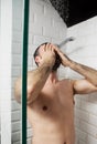 Handsome naked young man taking shower in bathroom