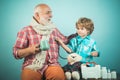 Handsome old man grandfather is having pain and his grandson supports him. Happy child pharmacist showing drug to senior Royalty Free Stock Photo