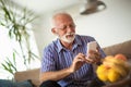 Handsome old man using a smartphone and smiling Royalty Free Stock Photo