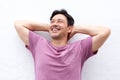 Handsome older man standing with hands behind his head on white background