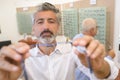 Handsome ophthalmologist handing over pair eye glasses to patient Royalty Free Stock Photo