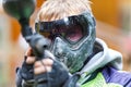 Handsome paintball player aiming in camera. Closeup.