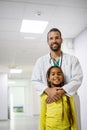 Pediatrician doctor smiling with his little girl patient at hospital Royalty Free Stock Photo