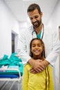 Pediatrician doctor smiling with his little girl patient at hospital Royalty Free Stock Photo