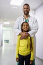 Pediatrician doctor smiling with his little girl patient at hospital Royalty Free Stock Photo