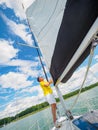 Handsome person raise the sail on a sailing yacht, summer vacations on sailboat