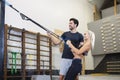 Handsome Personal Trainer Instructor While Helping Young Blond Female Doing Correct Stretching Excercise In Gym