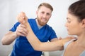 handsome physiotherapist treating patients shoulder