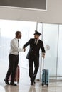 handsome pilot handshaking with young businessman