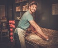 Handsome pizzaiolo rolling dough with rolling-pin. Royalty Free Stock Photo