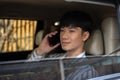 A handsome and positive Asian businessman is talking on the phone while driving his car Royalty Free Stock Photo
