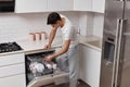 handsome positive man putting plates in dishwasher machine Royalty Free Stock Photo