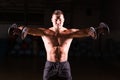 Handsome power athletic guy bodybuilder doing exercises with dumbbell. Fitness muscular body on dark background Royalty Free Stock Photo