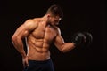 Handsome power athletic man with dumbbell confidently looking forward. Strong bodybuilder with six pack, perfect abs Royalty Free Stock Photo