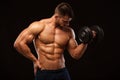 Handsome power athletic man with dumbbell confidently looking forward. Strong bodybuilder with six pack, perfect abs Royalty Free Stock Photo